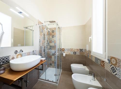 a bathroom with a sink and a shower and a toilet at Ponente & Maestro Rooms in Favignana