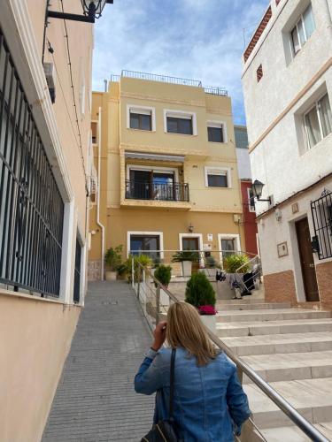 a woman taking a picture of a building at Studio 45qm in Calpe Altstadt - ruhig & modern in Calpe