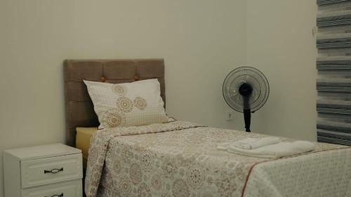 - une chambre avec un lit et un ventilateur dans l'établissement Taş tatil evleri, à Aydın