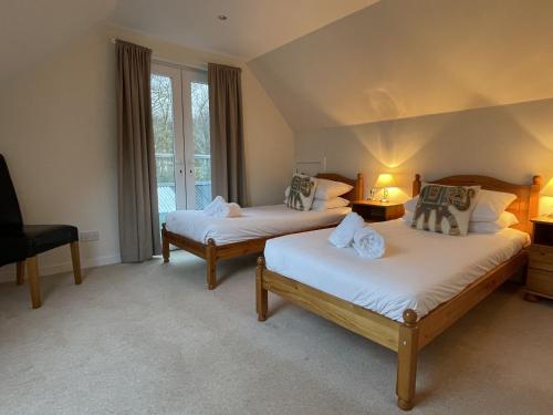 a bedroom with two beds and a window at The Cottage, overlooking Loch Fyne in Cairndow