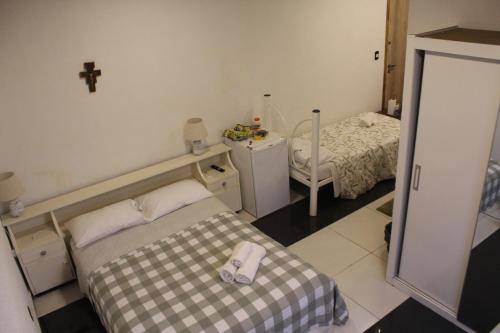 Pokój z dwoma łóżkami i krzyżem na ścianie w obiekcie AP 10- Apart OH w mieście Ciudad del Este