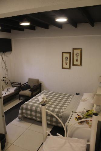 Cette chambre comprend un lit, un canapé et une chaise. dans l'établissement AP 10- Apart OH, à Ciudad del Este
