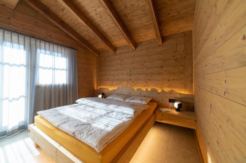 um quarto com uma cama num quarto de madeira em Chalet Gamserrugg em Wildhaus