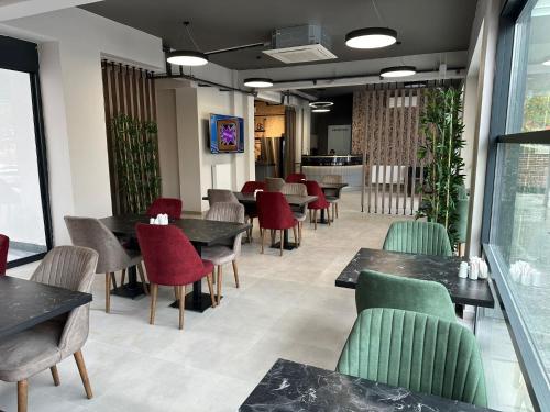 a dining room with tables and red chairs at MARASIUM SUITES in Kahramanmaras