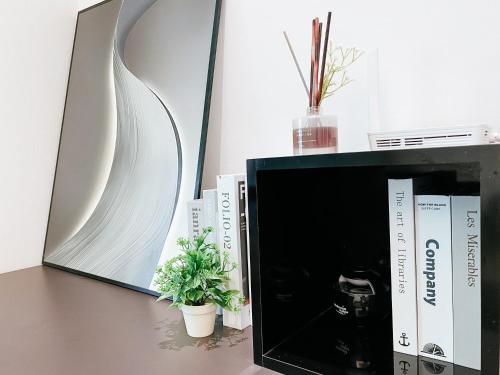 Hartamas - Cozy Studio - 3min to Publika KL في كوالالمبور: جلسة مرآة بجانب مكتب فيه كتب وتلفزيون