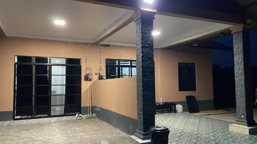 a room with two pillars and a room with a glass door at Bella Homestay in Kampong Bari Kechil