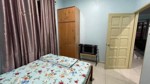 a bedroom with a bed and a closet and a door at Bella Homestay in Kampong Bari Kechil