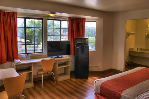 エンフィールドにあるMotel 6-Enfield, CT - Hartfordのベッドと机、テレビが備わったホテルの部屋
