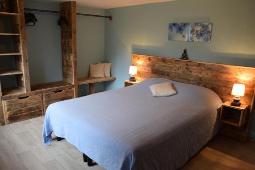 a bedroom with a white bed and two lamps at Gîte du Baroudeur in Spa