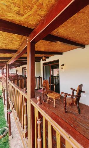 a wooden deck with a bench and a chair on it at Hotel Vista Verde in Huancayo