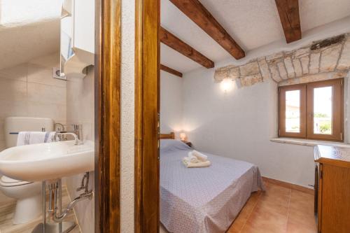 La salle de bains est pourvue d'un lavabo et d'un lit dans la chambre. dans l'établissement Villa Zinnia, à Fabci