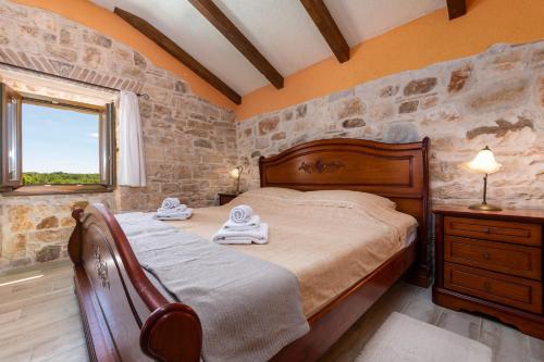 een slaapkamer met een bed en een stenen muur bij Villa Zinnia in Fabci
