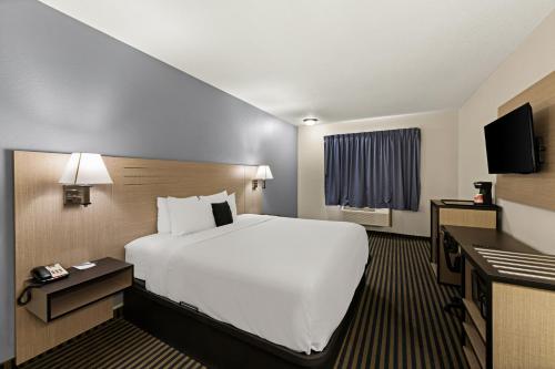 a hotel room with a large bed and a television at Red Lion Inn & Suites Gretna - Omaha SW in Gretna