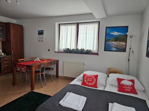 a room with a bed and a table with a desk at Apartament Granit in Zakopane