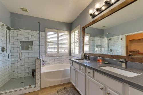 uma casa de banho com 2 lavatórios, uma banheira e um chuveiro em Charming Gilbert Home with Patio and Putting Green! em Queen Creek