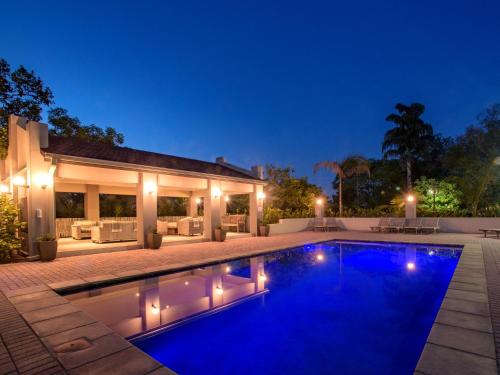 a swimming pool in front of a house at night at Monkey Thorn Lodge & Wellness Spa - Adults Only in White River