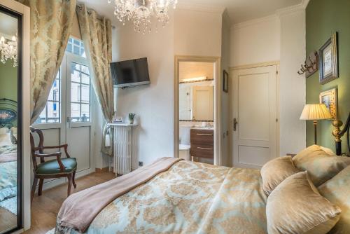 a bedroom with a bed and a chair and a window at Hotel Boutique Las Brisas in Santander