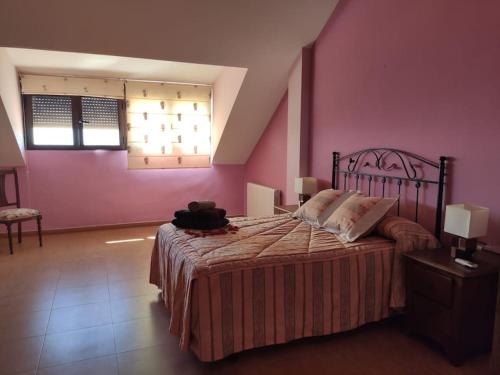 1 dormitorio con 1 cama grande y paredes de color rosa en Balcón del Guadalquivir, en Baeza