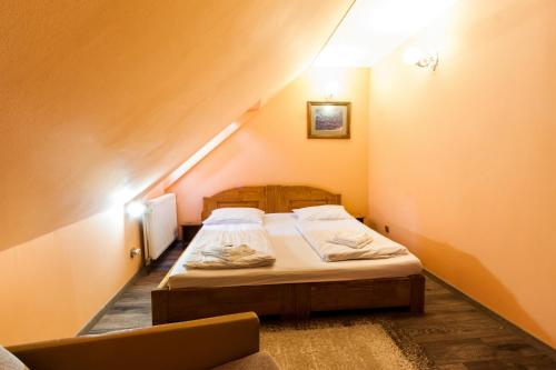 a small bedroom with a bed in a attic at Pensiune si Restaurant Anda in Gheorgheni