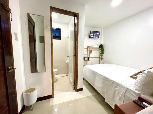 a small bedroom with a bed and a bathroom at Namal Apartelle - Free Scooter & GYM access in El Nido