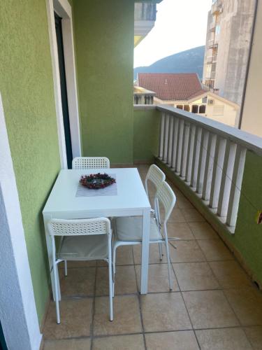 uma mesa branca e cadeiras numa varanda em Apartment VaLi em Herceg-Novi