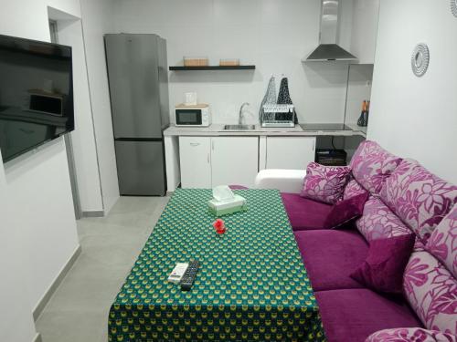 sala de estar con sofá púrpura en la cocina en Apartamentos los carros 2 en Guadix
