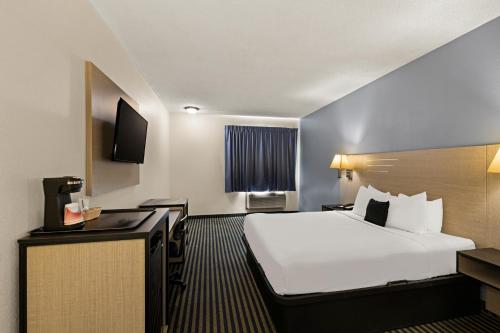 a hotel room with a bed and a television at Red Lion Inn & Suites Gretna - Omaha SW in Gretna
