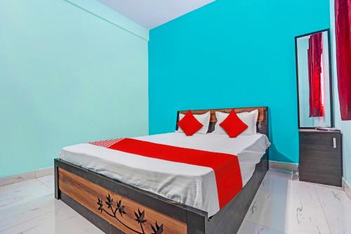 Schlafzimmer mit einem Bett mit roten und blauen Wänden in der Unterkunft OYO Hotel R R in Nagpur