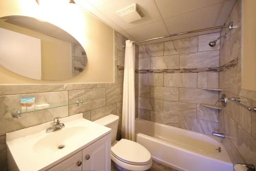 y baño con lavabo, aseo y ducha. en Surf Villa Apartments en Ocean City
