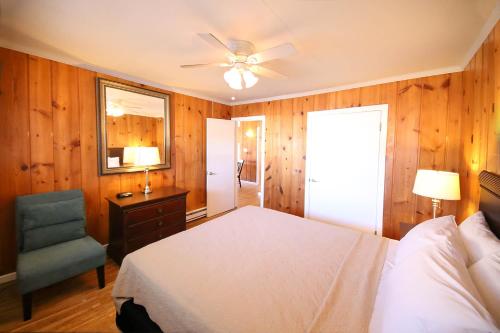 sypialnia z łóżkiem, krzesłem i wentylatorem sufitowym w obiekcie Surf Villa Apartments w mieście Ocean City