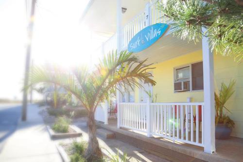 a yellow building with palm trees in front of it at Surf Villa Apartments in Ocean City