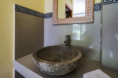 a bathroom with a large rock sink on a counter at Big Stone House 7 - 6 min Center and 500m Parq Ubud in Ubud