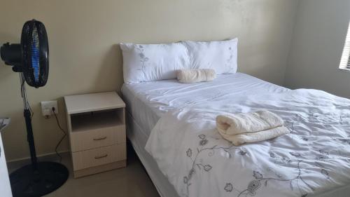 1 dormitorio con 1 cama con 2 toallas en Airport Airbnb family units, en Richards Bay