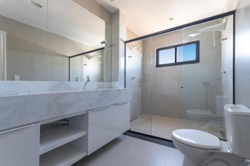 La salle de bains est pourvue de toilettes et d'une douche en verre. dans l'établissement Bosque da Praia #105 - Casa em Jacumã by Carpediem, à Jacumã