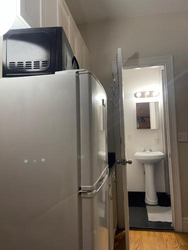 Midtown Nest 1 bedroom Self Serviced Apartment في نيويورك: ثلاجة فيها مايكرويف فوق الحمام