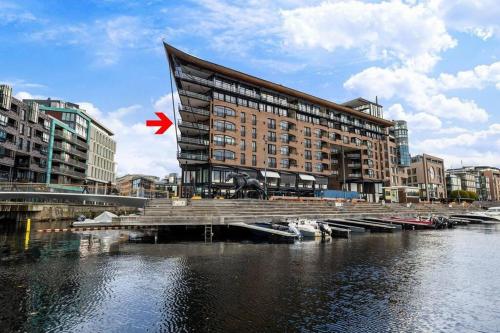 a building with a red flag in front of a river at Large 41 millions kr Apartment - seaview in center in Oslo