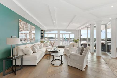 a living room with a white couch and chairs at Large 41 millions kr Apartment - seaview in center in Oslo