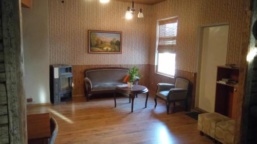 - un salon avec un canapé, une table et des chaises dans l'établissement Vana Postimaja Accommodation, à Suure-Jaani