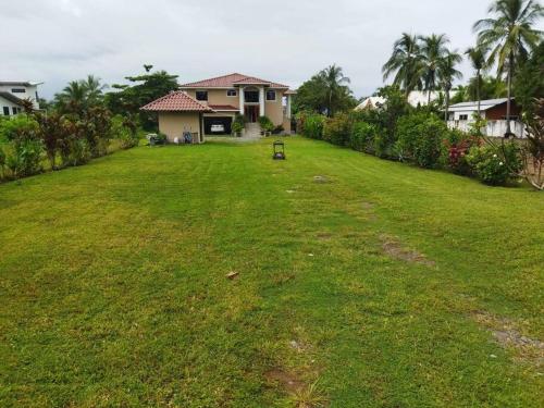 a large yard with a house and a grass yard at Casa Pacifico Panama in Las Lajas