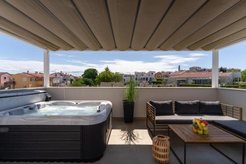 - Balcón con bañera de hidromasaje, mesa y sofá en Costa Deluxe, en Funtana