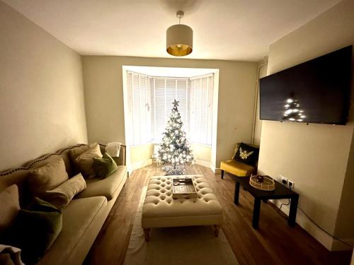a living room with a christmas tree and a couch at Three bed, forest view home in Cwmcarn