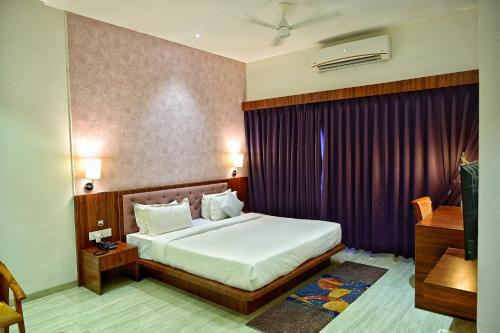 ナーシクにあるThe One Hotel Nashikのベッドルーム(ベッド1台、紫色のカーテン付)