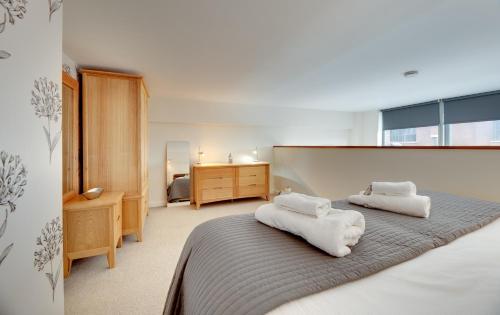 een slaapkamer met een bed met handdoeken erop bij Crown Apartments 104 by Week2Week in Newcastle upon Tyne