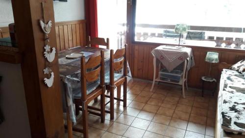 a dining room with a table and chairs and a window at Les Silenes in Bellevaux