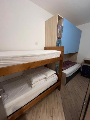 two bunk beds in a room with wooden floors at Gran Baita Residence in Passo del Tonale
