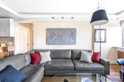 - un salon avec un canapé gris et des oreillers rouges dans l'établissement Muette - Spontini 1bdr by B'Your Home, à Paris