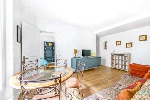un salon avec une table en verre et un canapé dans l'établissement Montmartre - Lamarck - Caulaincourt 2bdr, à Paris
