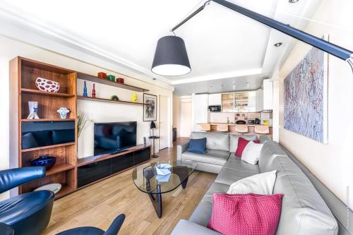 un salon avec un canapé et une télévision dans l'établissement Muette - Spontini 1bdr by B'Your Home, à Paris