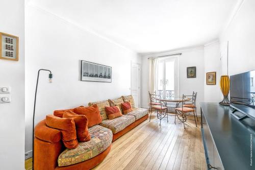 un salon avec un canapé et une table dans l'établissement Montmartre - Lamarck - Caulaincourt 2bdr, à Paris
