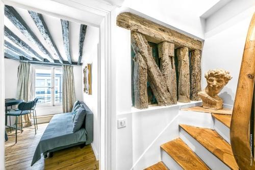 a living room with a stairway leading up to a door with a sculpture at Grands Boulevards - Vivienne 1bdr in Paris